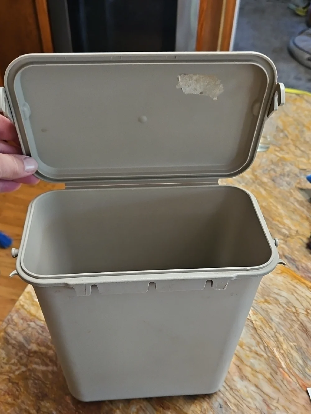 a plastic kitchen compost caddy or food waste bin with a lid and sturdy handle.